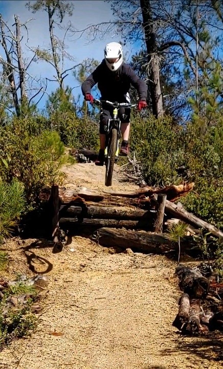Person jumping mountain bike over obstacle
